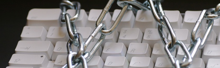 Computer Keyboard with metal chains wrapped around it symbolizing writer's block